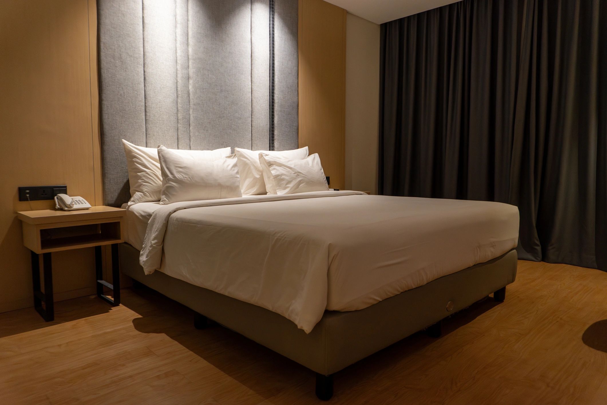 Neatly made double bed in a bright room